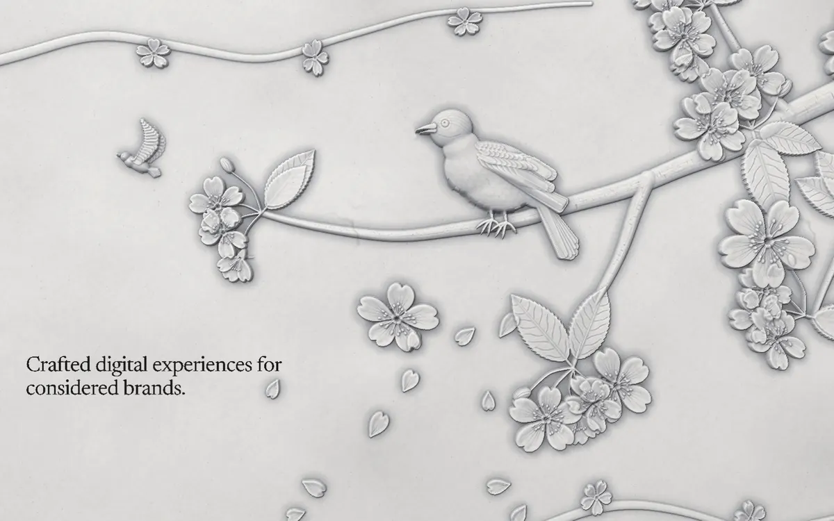 The Plaster template: a songbird perched on a flowering cherry branch, carved into a grey plaster wall beside a studio headline